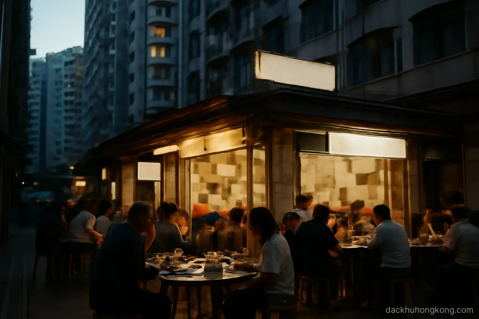 a small busy eatery with closely packed tables at street level beneath a tall residential block in the evening
