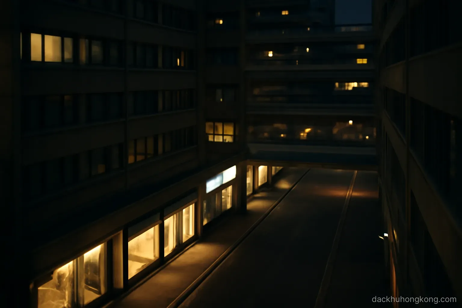 the same stretch of street seen at night from a high window, with lit shopfronts below and layered walkways between towers